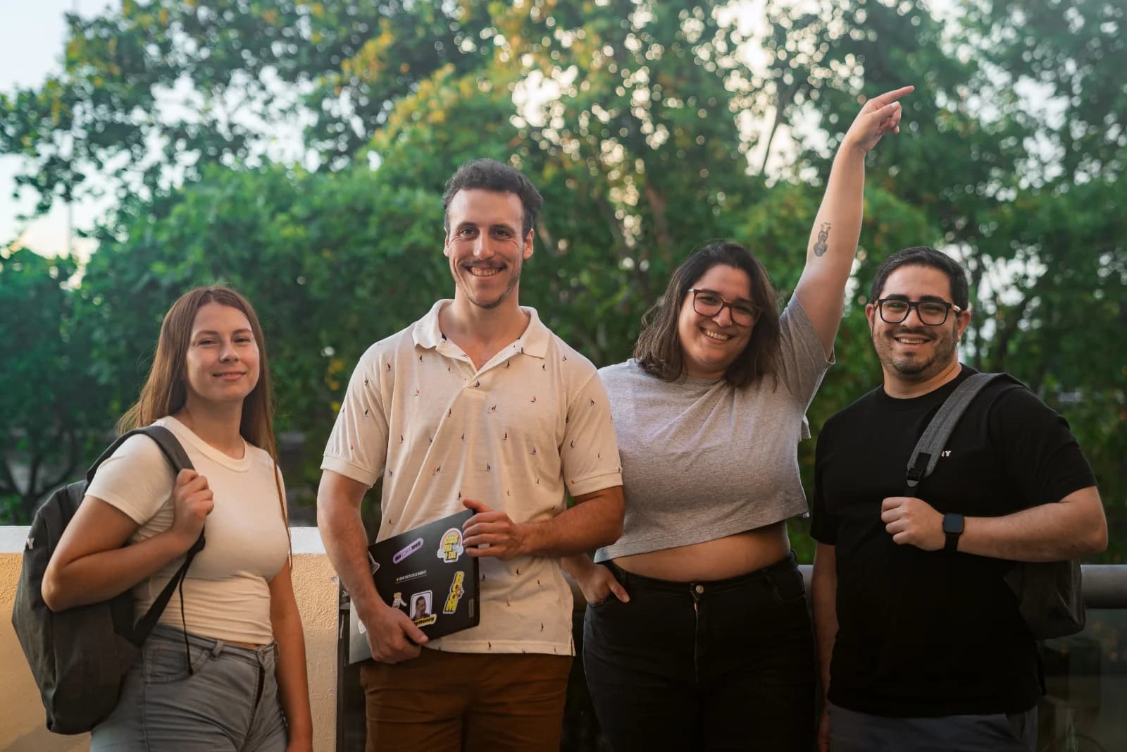 Cuatro integrantes de la comunidad de Henry sonriendo al aire libre.
